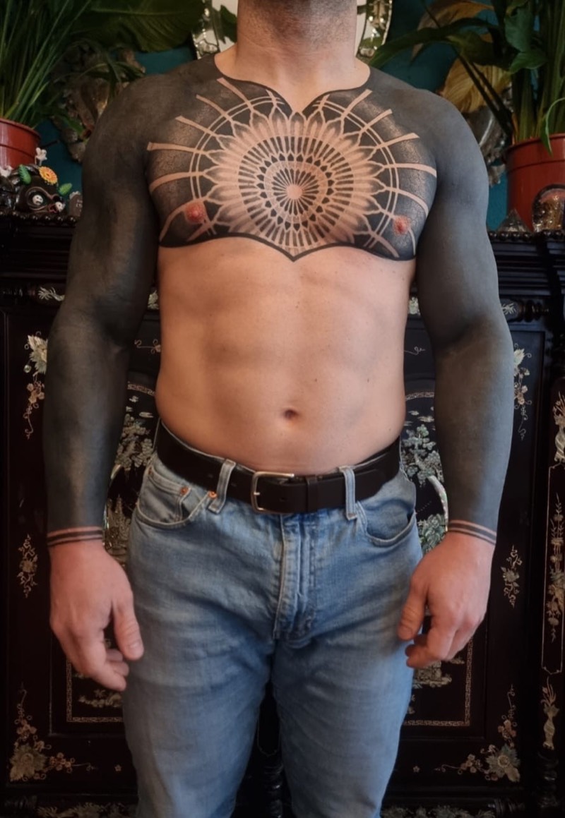 Blackwork chest mandala with blacked-out arms