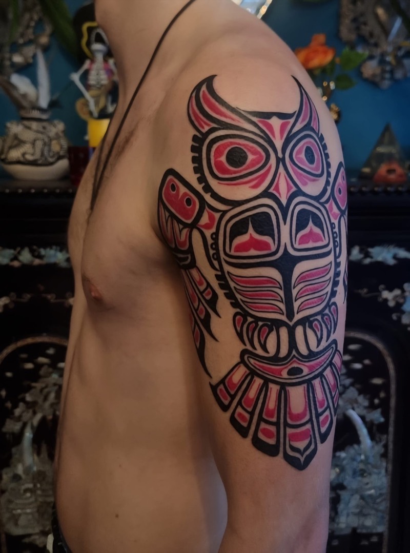 Haida-style owl upper arm tattoo